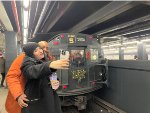 A couple posing for a selfie in front of the Holiday Train at 2nd Ave Station 